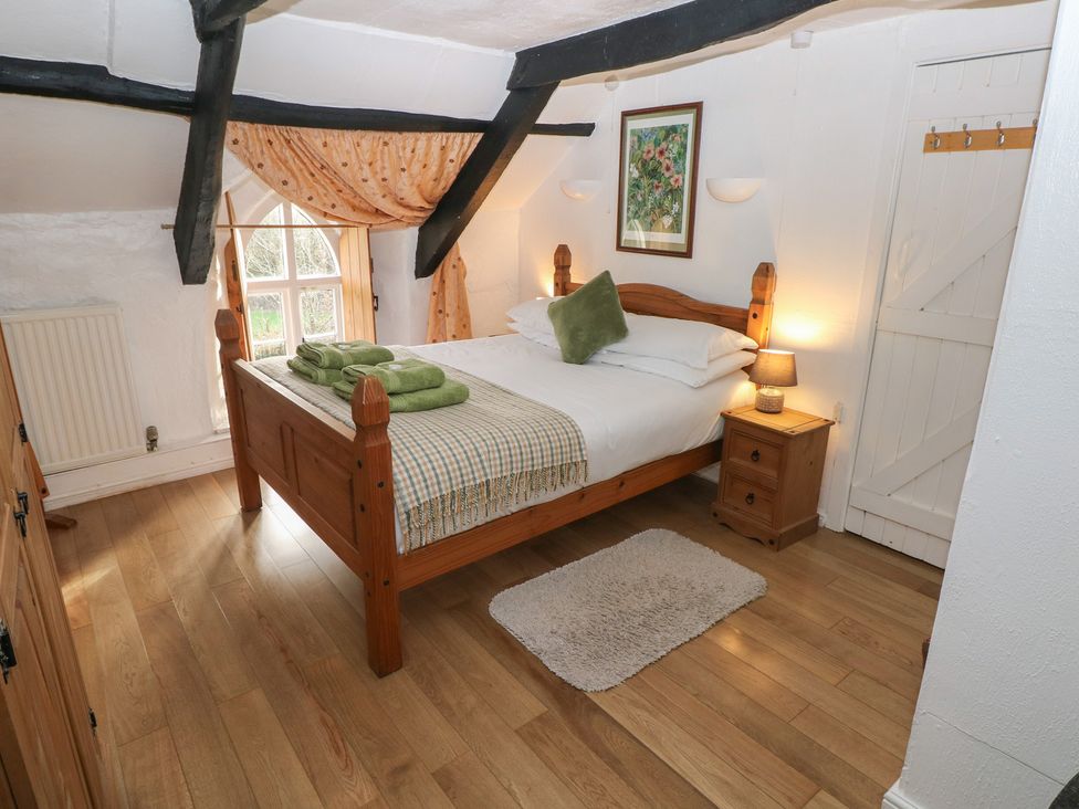 A bedroom with a bed and nightstand at Maesgwyn in Bridell near Cardigan