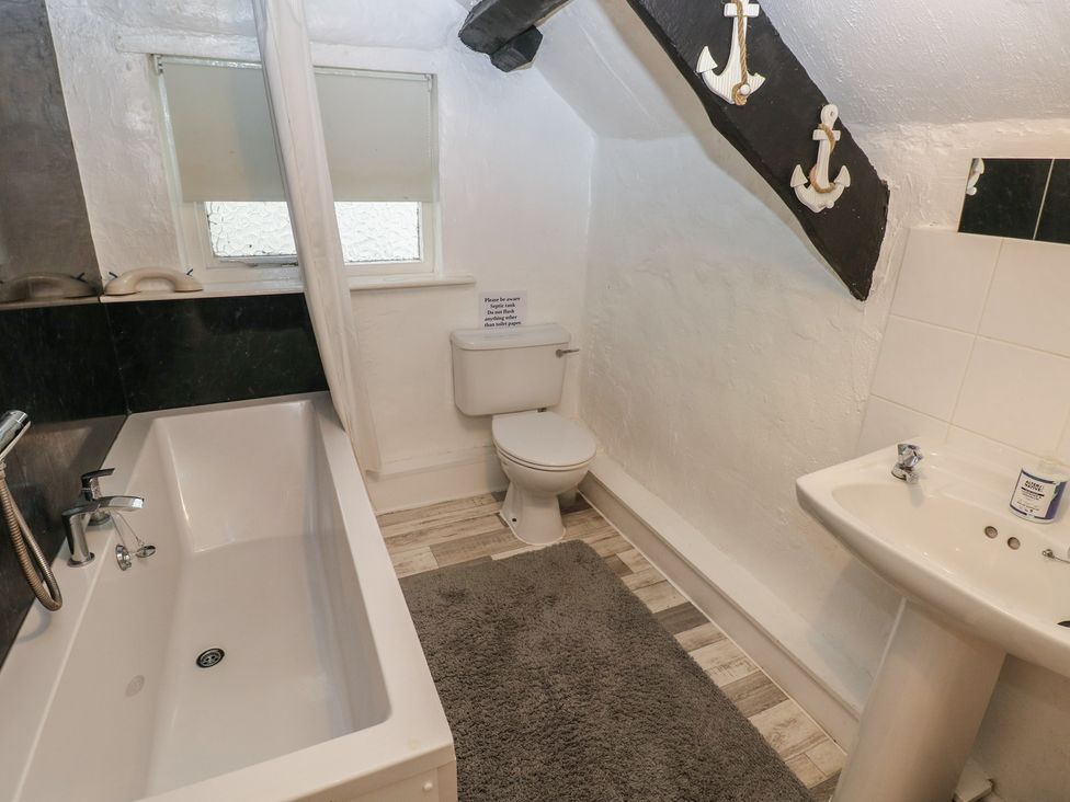 A bathroom with a bath, toilet, and sink at Maesgwyn in Bridell near Cardigan