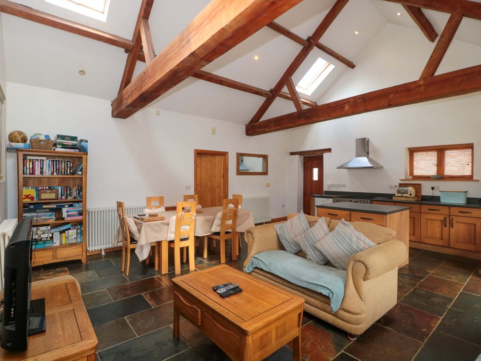 A living room with a television and dining area at Riverside Barn in Gilwern near Crickhowell and Abergavenny