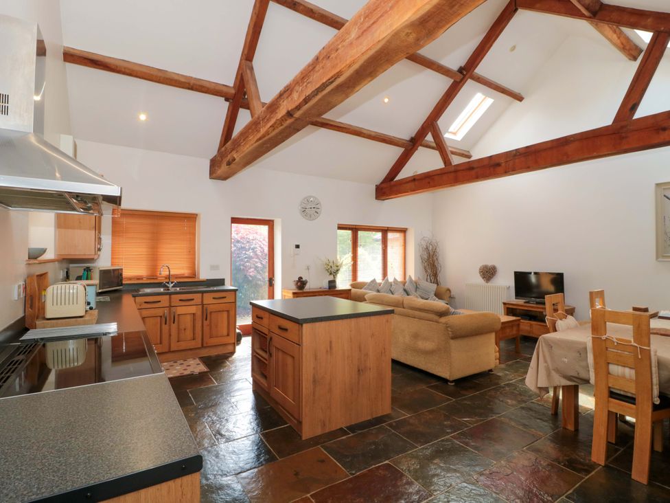 A kitchen with a dining area and living space at Riverside Barn in Gilwern near Crickhowell and Abergavenny