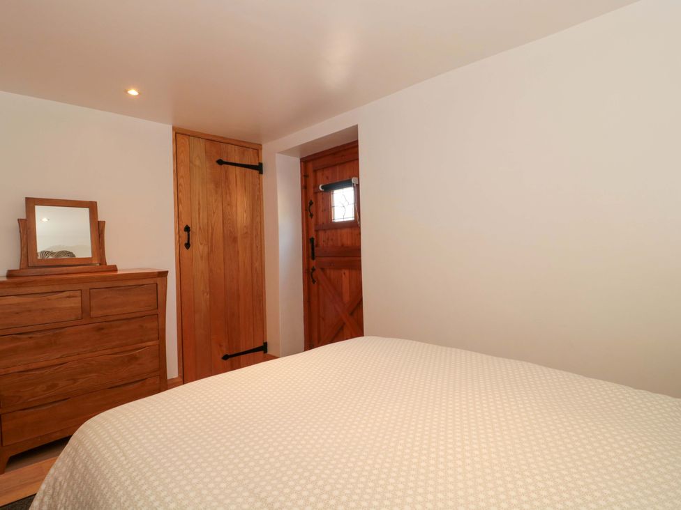 A bedroom with a bed and wooden furniture at Riverside Barn near Gilwern near Crickhowell and Abergavenny
