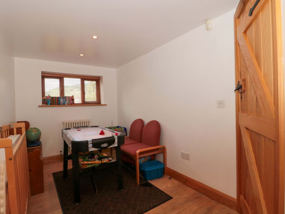 A snug with an air hockey table and chairs at Riverside Barn in Gilwern near Crickhowell and Abergavenny