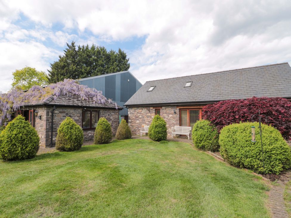 An outdoor view of a stone building with greenery at Riverside Barn Gilwern near Crickhowell and Abergavenny