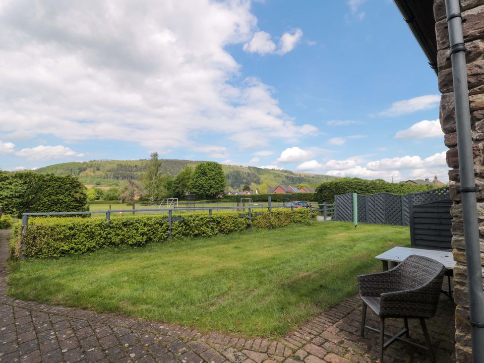 A garden with grass and seating area at Riverside Barn in Gilwern near Crickhowell and Abergavenny