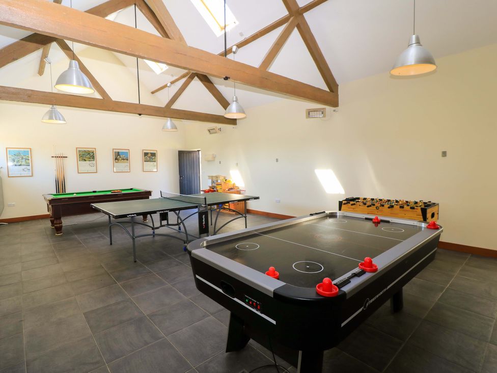 A game room with air hockey table ping pong table pool table and foosball table at The Old Cart Shed in Winterborne Stickland