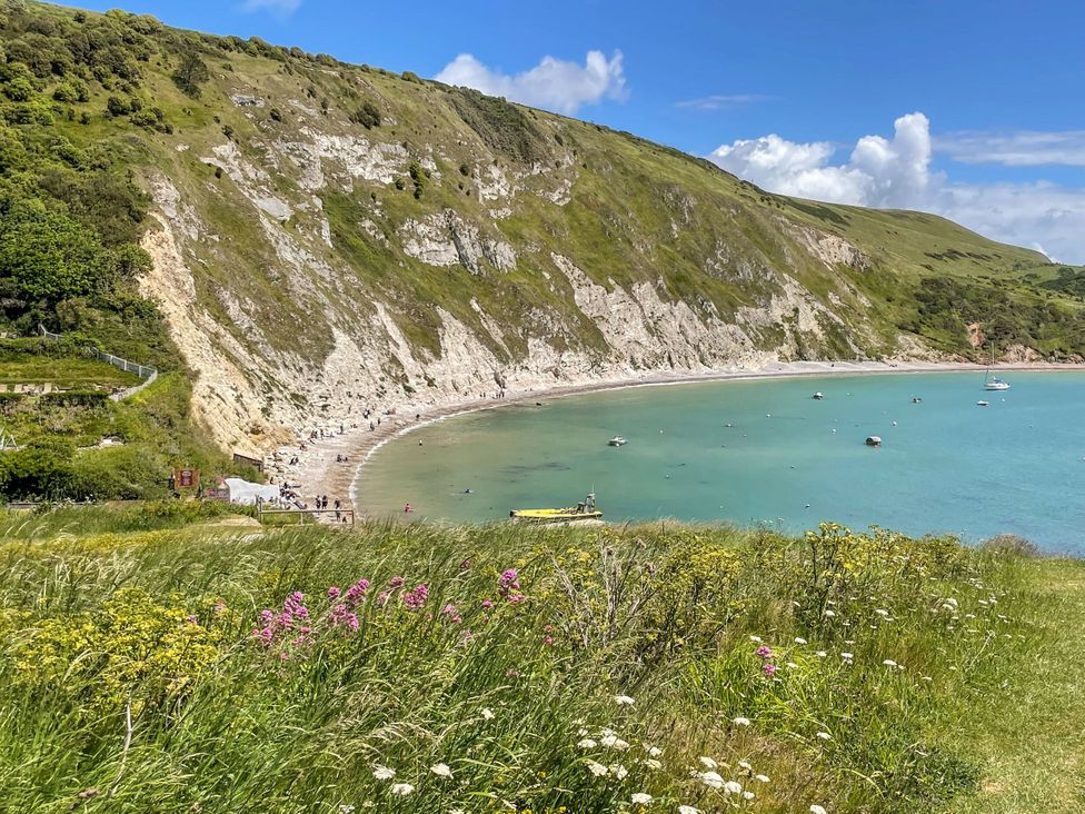 A beach with cliffs and boats at Rowdens Barn Winterborne Stickland