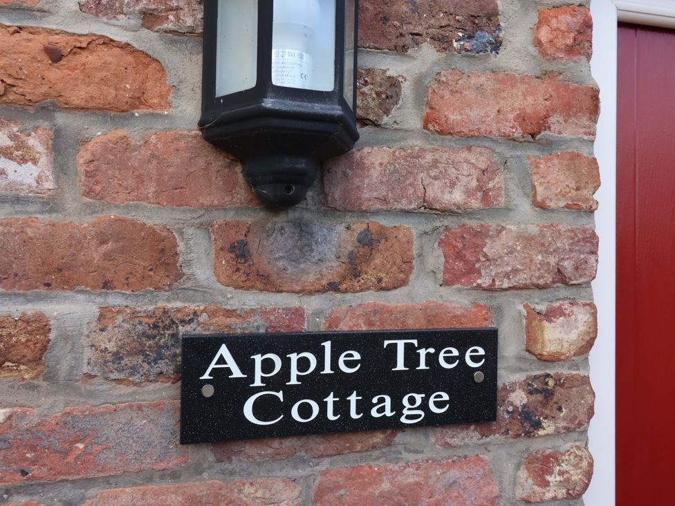 A sign stating Apple Tree Cottage on a brick wall at Apple Tree Cottage in Dunnington