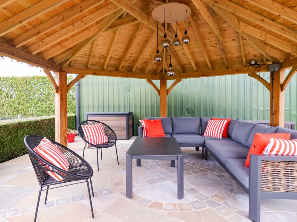 An outdoor seating area with a gazebo and furniture at Apple Tree Cottage in Dunnington