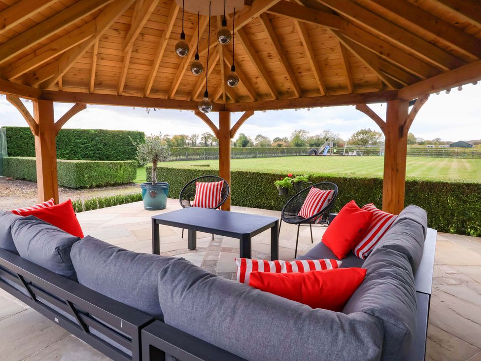 An outdoor seating area with a gazebo and chairs at Apple Tree Cottage in Dunnington