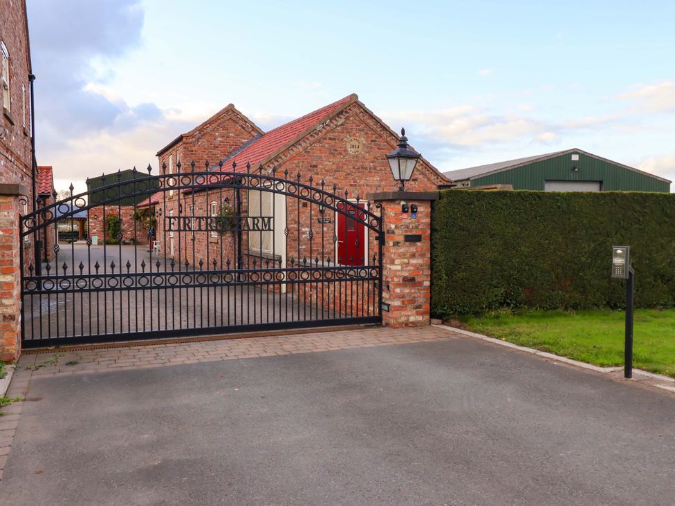 A gate with brick wall and driveway at Fir Tree Farm in Dunnington