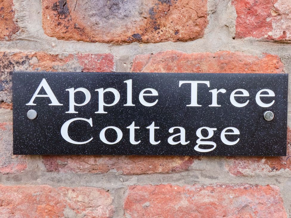 A sign that reads Apple Tree Cottage mounted on a brick wall at Apple Tree Cottage in Dunnington