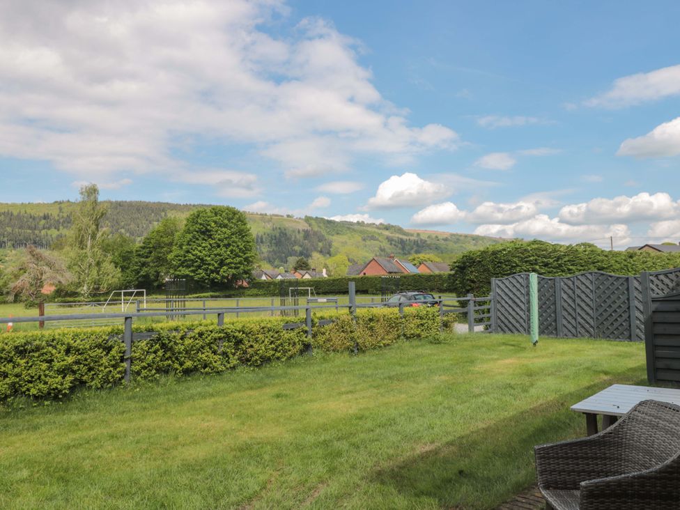 An outdoor view with grass and trees at Longside in Gilwern