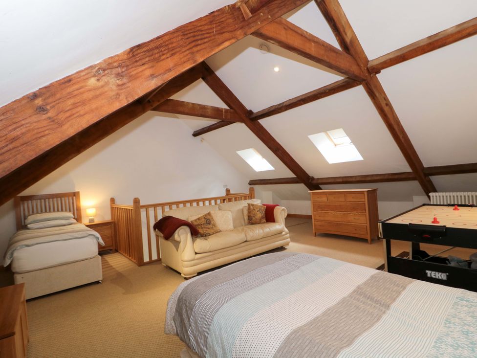 A loft with bed and sofa at Longside in Gilwern