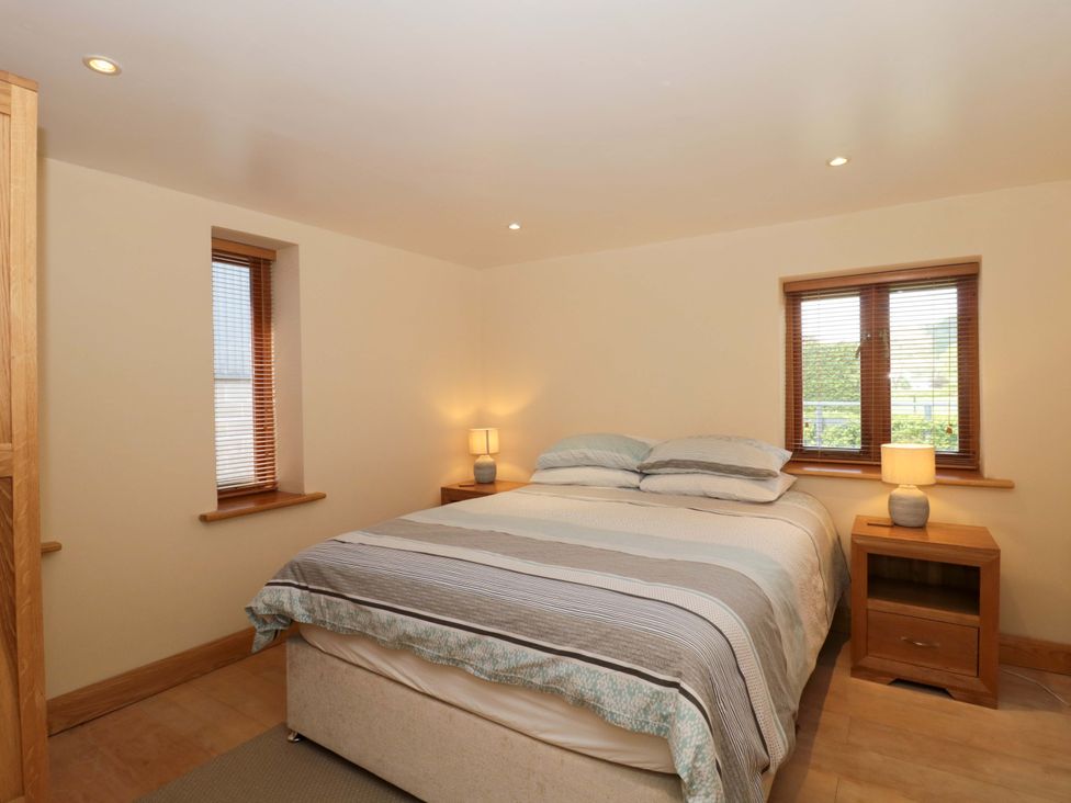 A bedroom with a bed and bedside table at Longside in Gilwern