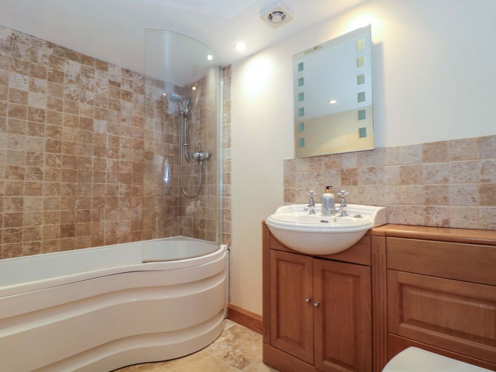 A bathroom with a bathtub and sink at Longside in Gilwern