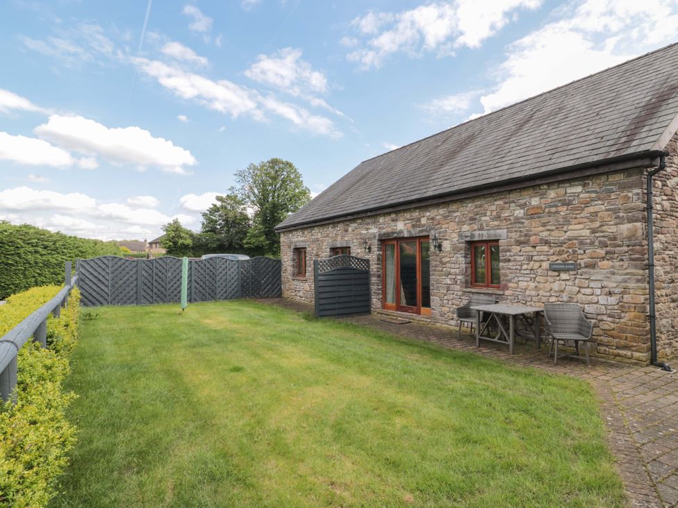 A garden area with a table and chairs at Longside in Gilwern