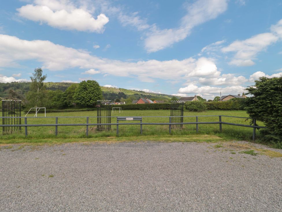 A grassy area with goalposts and a fence at Longside in Gilwern