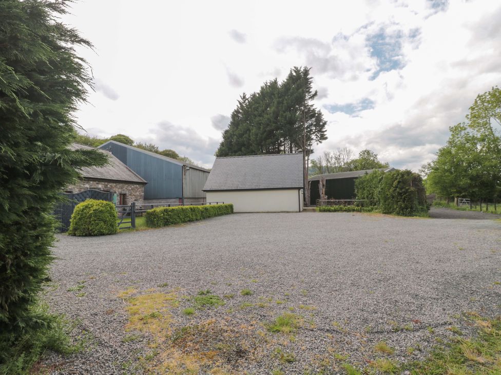 An outdoor area with gravel surface and multiple buildings at Longside in Gilwern