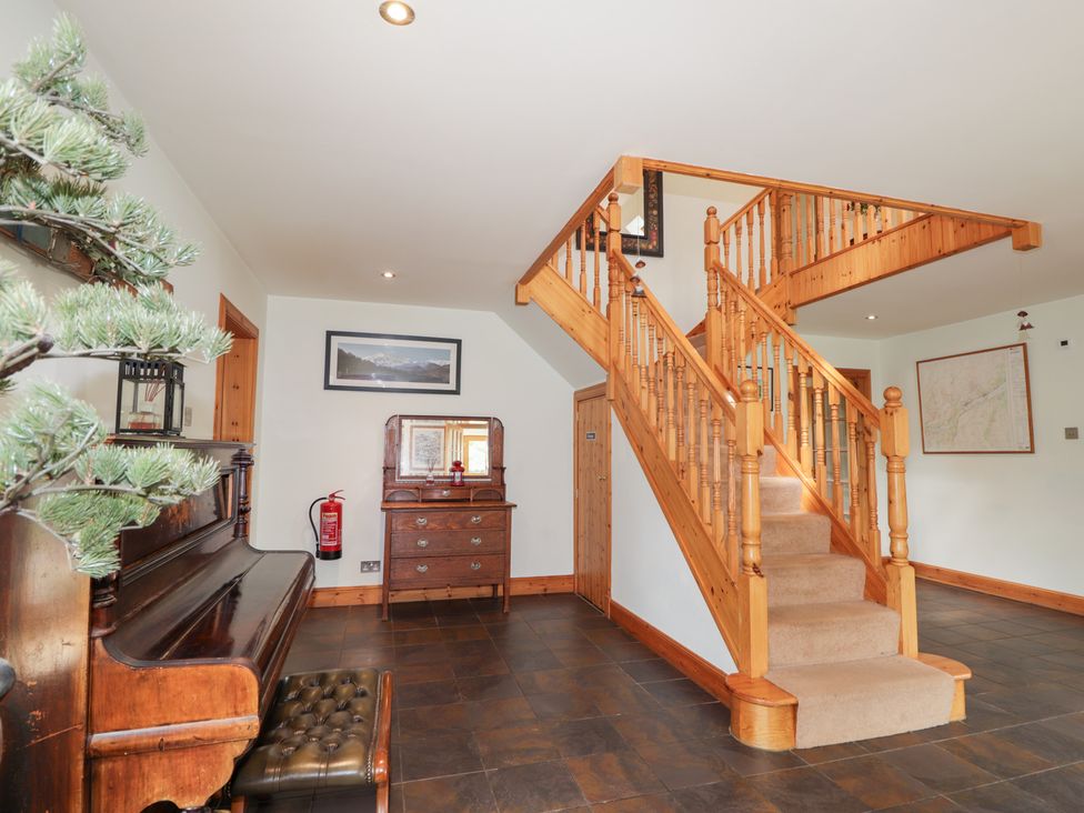 A hallway with a staircase and a console table at An Torr in Newtonmore