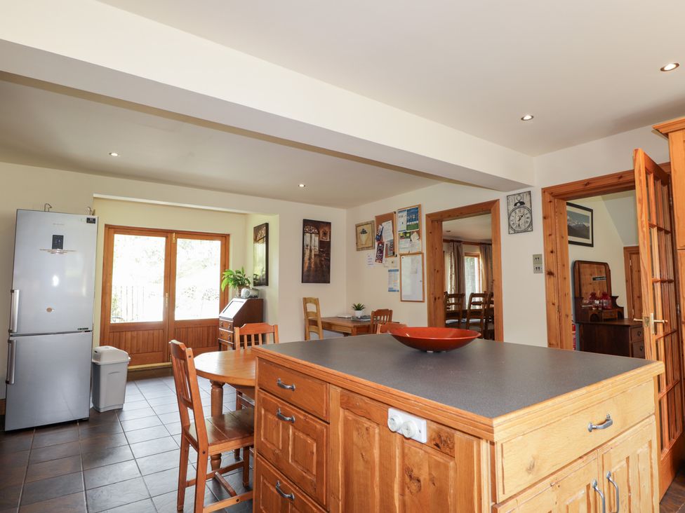 A kitchen with a refrigerator and dining area at An Torr in Newtonmore
