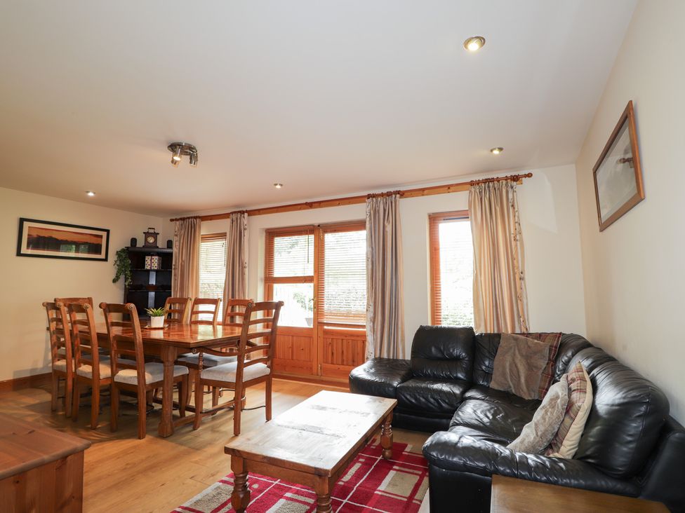 A living room with a dining area and a sofa at An Torr in Newtonmore