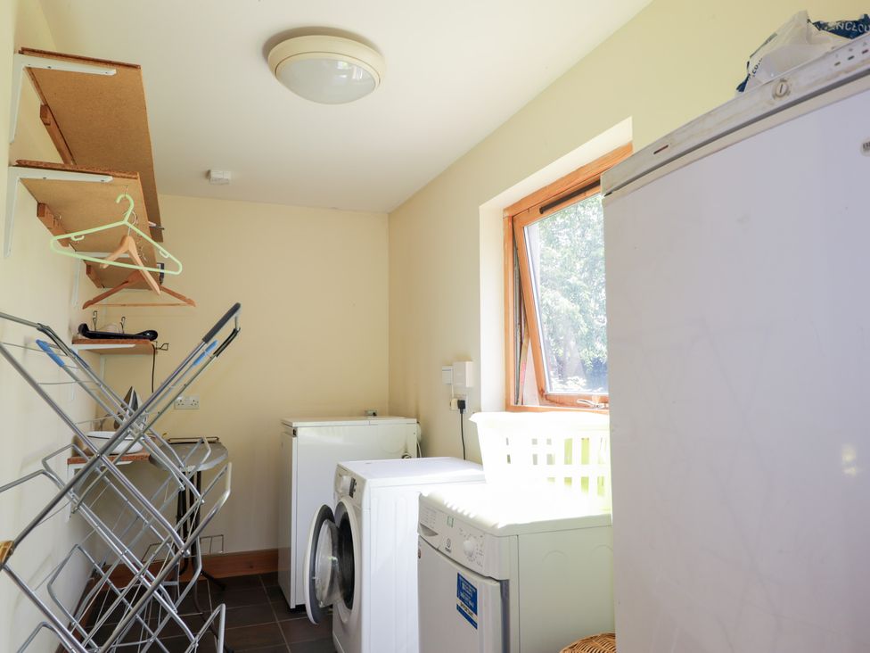 A laundry room with appliances and drying rack at An Torr in Newtonmore