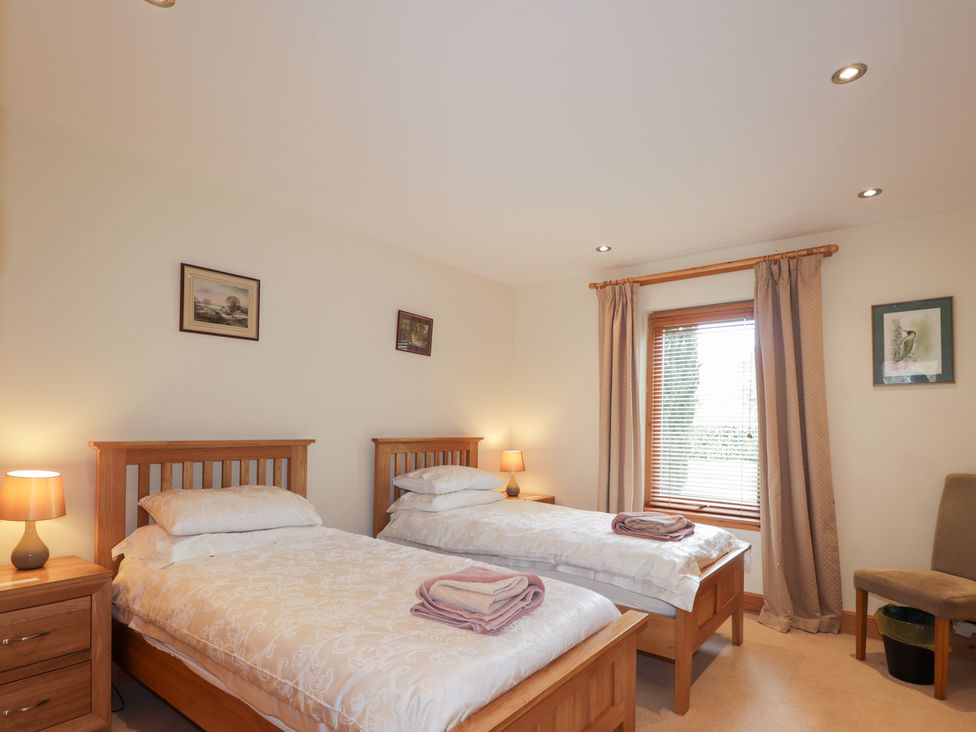 A bedroom with twin beds and a window at An Torr in Newtonmore
