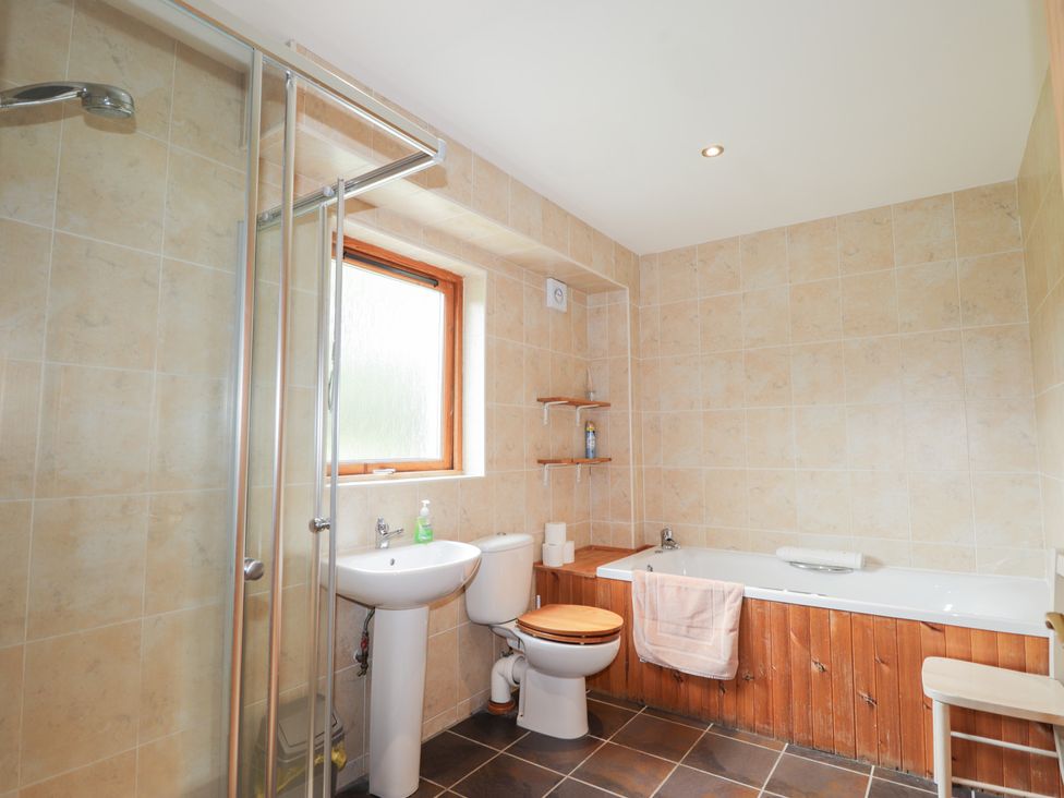 A bathroom with a shower, bathtub, and sink at An Torr in Newtonmore