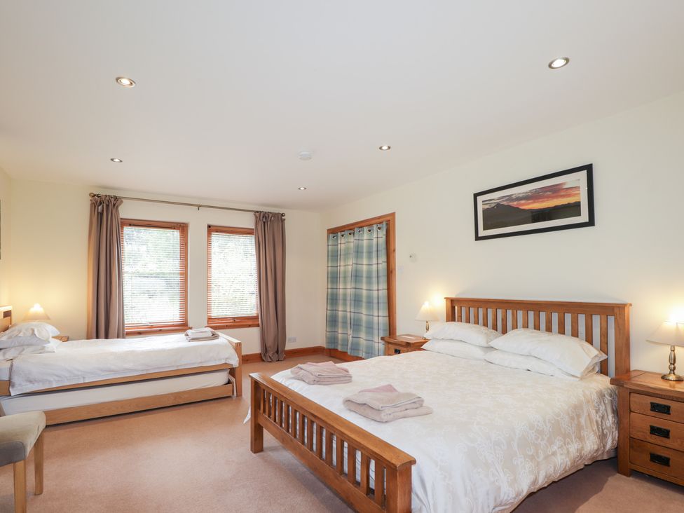 A bedroom with a double bed and a single bed at An Torr in Newtonmore