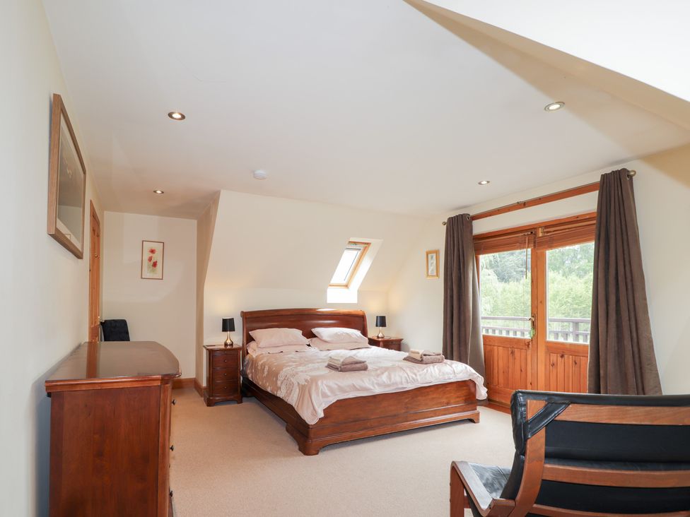 A bedroom with a bed and dresser at An Torr in Newtonmore