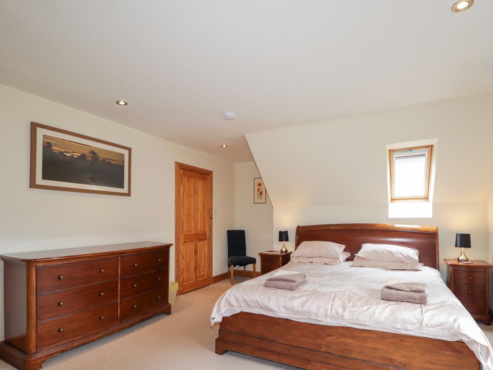 A bedroom with a bed and dresser at An Torr in Newtonmore