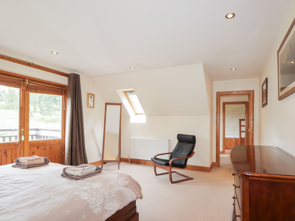 A bedroom with a bed and a mirror at An Torr in Newtonmore