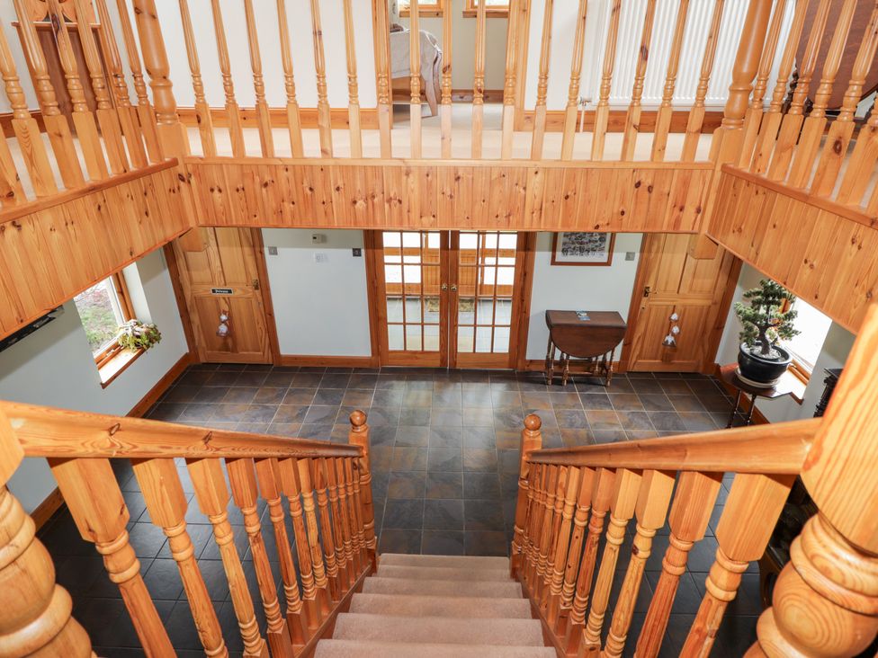 An entrance hall with staircase and table at An Torr in Newtonmore