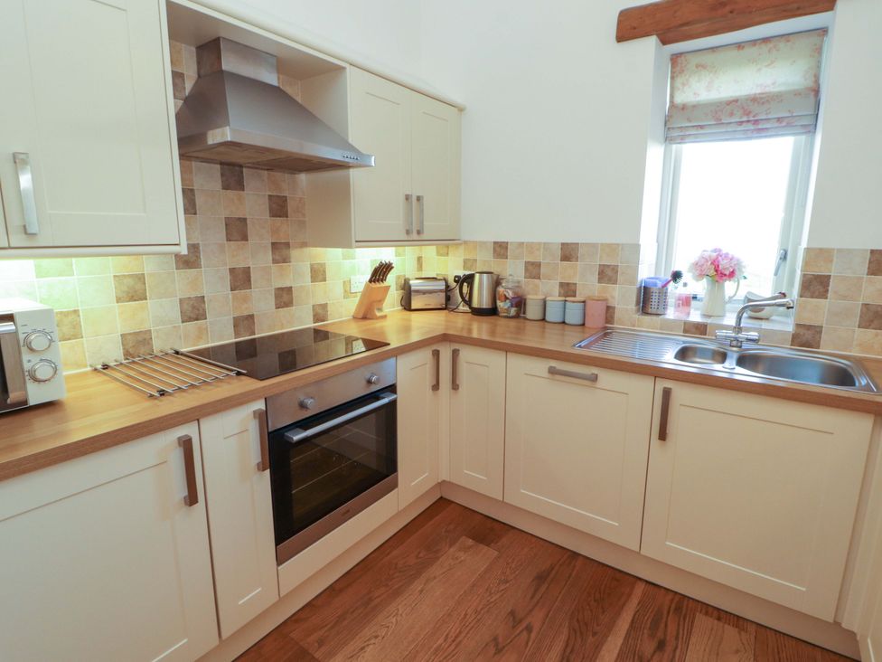 A kitchen with an oven and sink at Hawkrigg Cottage Kirkby Lonsdale