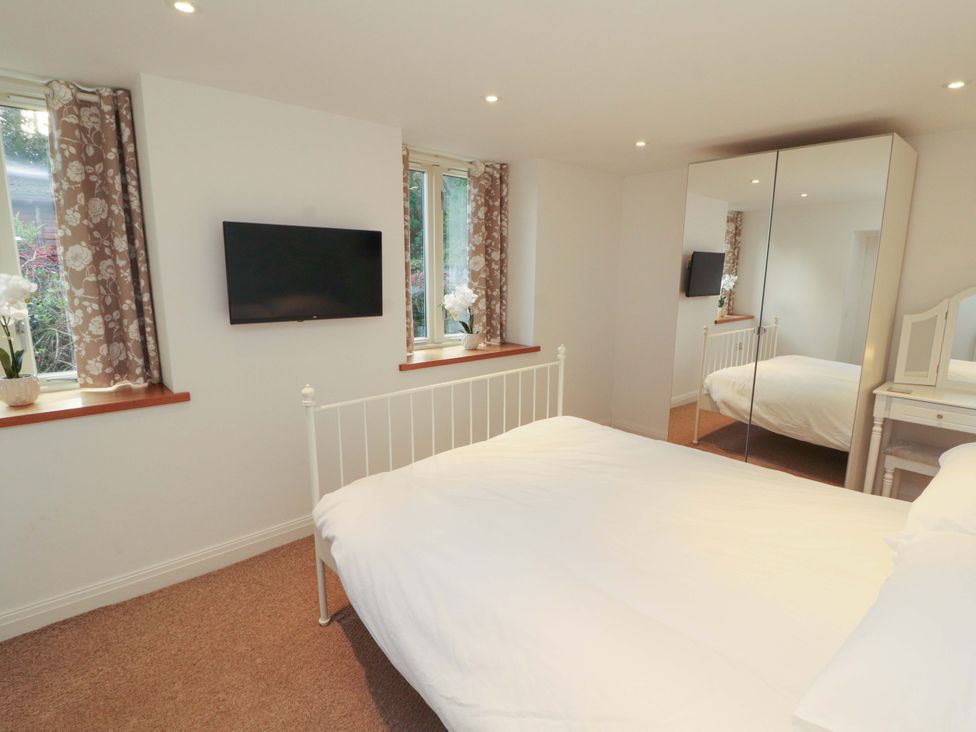 A bedroom with a bed and television at Hawkrigg Cottage in Kirkby Lonsdale