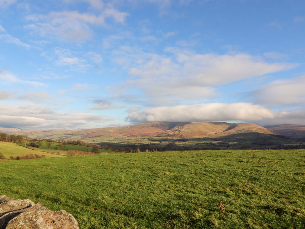 A scenic view of mountains and fields at Hawkrigg Cottage in Kirkby Lonsdale
