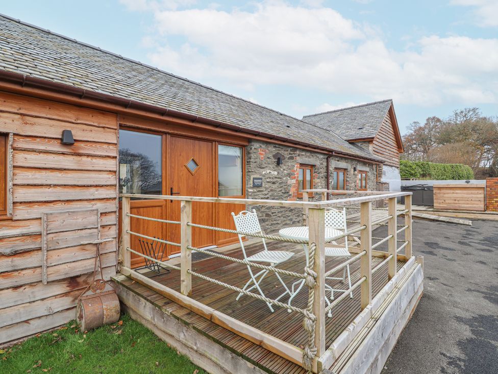 An outdoor area with table and chairs at Rhianwen, Plas Moelfre Hall Barns in Llanrhaeadr-ym-Mochnant