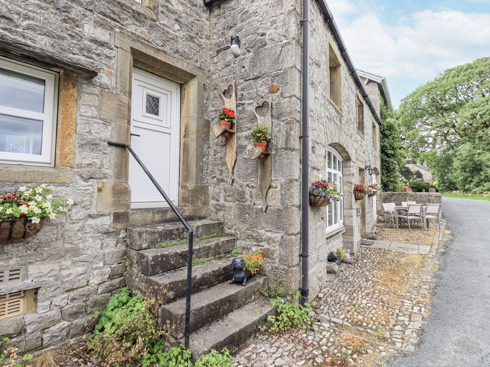 An exterior view of a house with stone walls and steps at The Stables in Horton-in-Ribblesdale near Settle