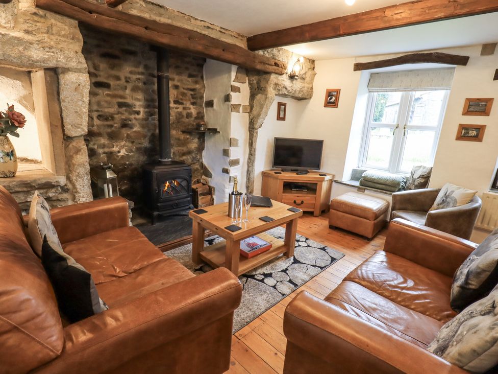 A living room with a stove and seating area at The Stables in Horton-in-Ribblesdale near Settle