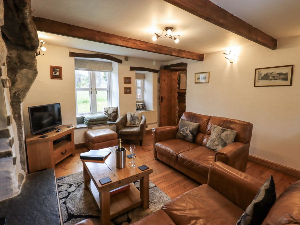 A living room with a television and brown leather furniture at The Stables in Horton-in-Ribblesdale near Settle