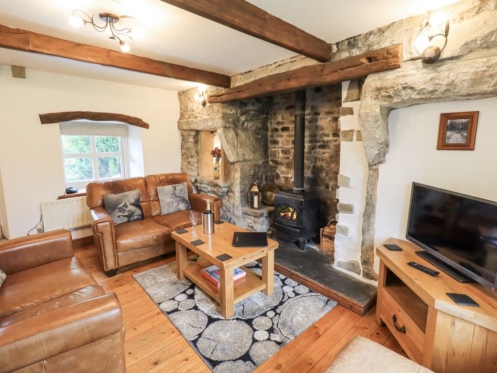 A living room with a fireplace and sofa at The Stables in Horton-in-Ribblesdale near Settle