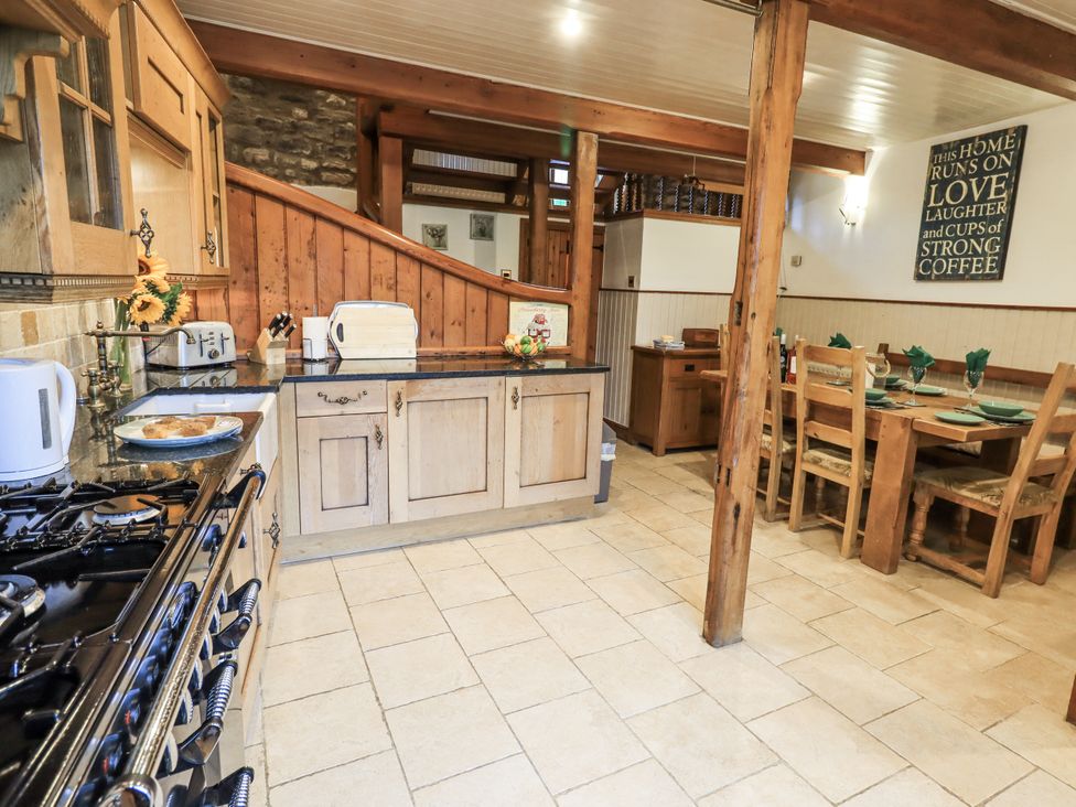 A kitchen with wooden furniture and a dining area at The Stables in Horton-in-Ribblesdale near Settle