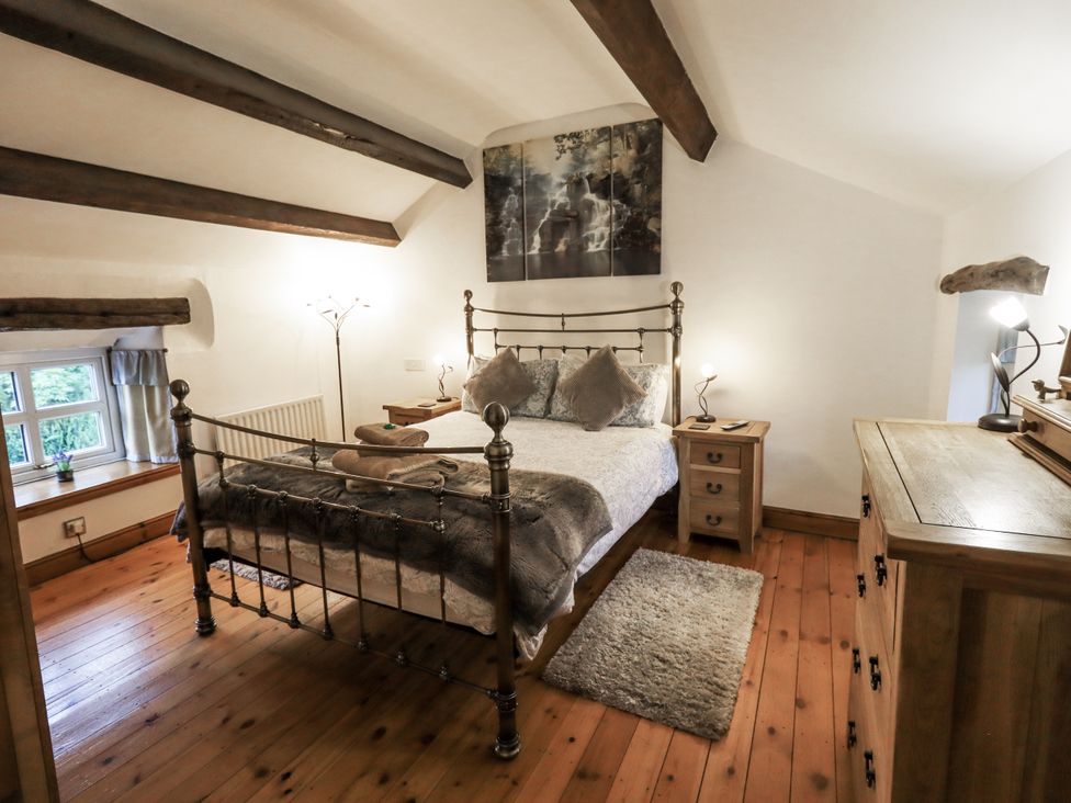 A bedroom with a bed, bedside table, and dresser at The Stables in Horton-in-Ribblesdale near Settle