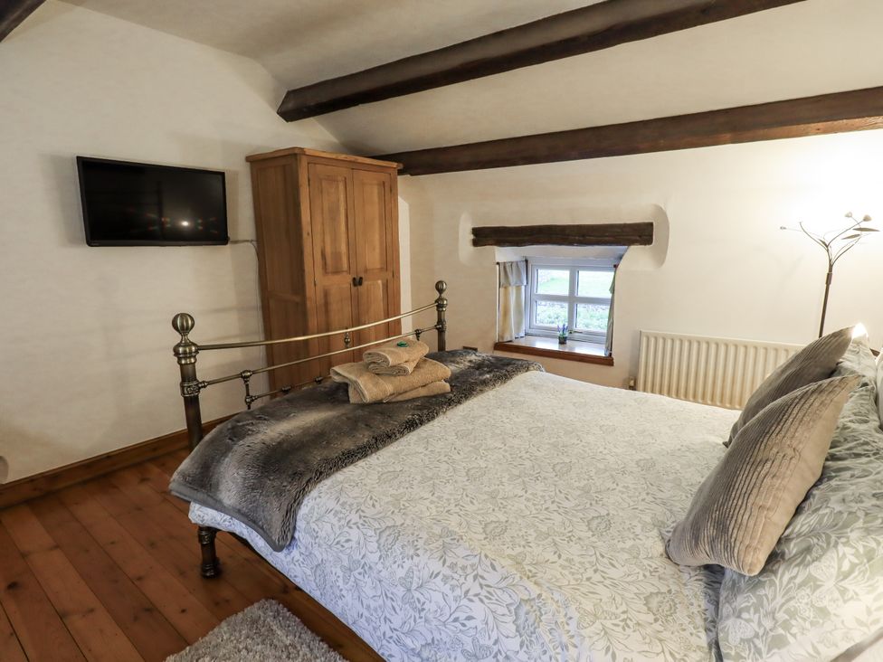 A bedroom with a bed and wardrobe at The Stables in Horton-in-Ribblesdale near Settle