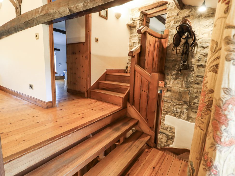 A hallway with a wooden staircase and light fixtures at The Stables in Horton-in-Ribblesdale near Settle