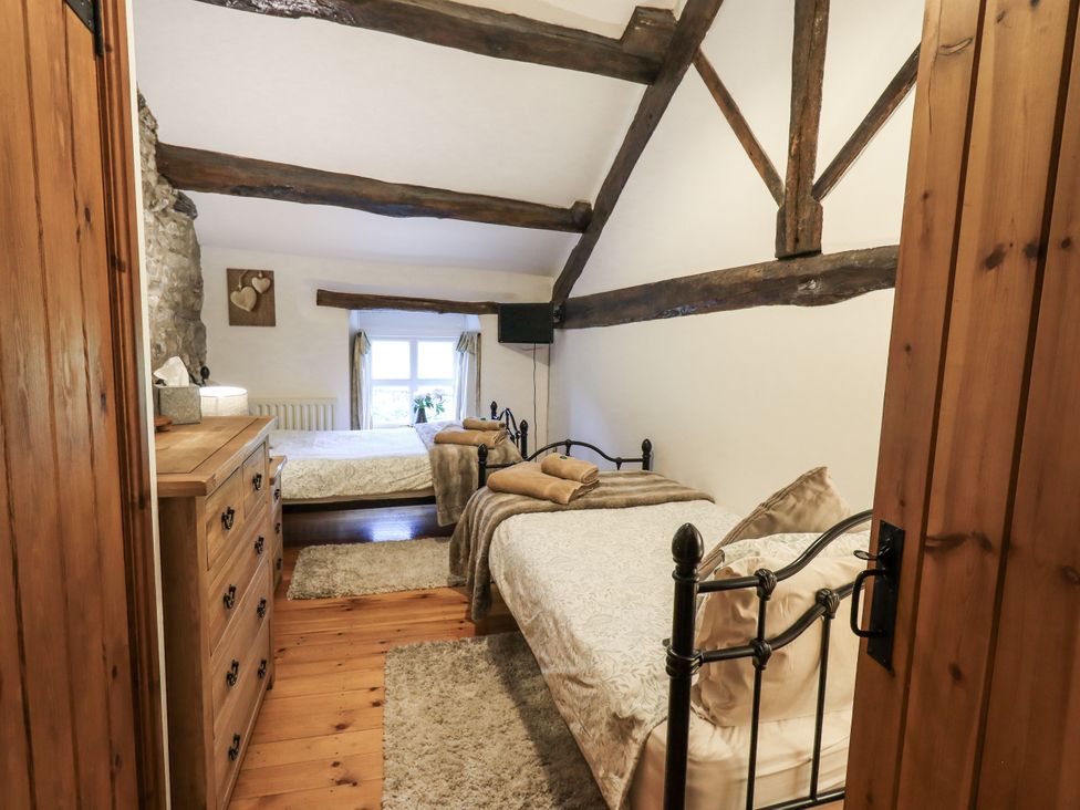 A bedroom with two beds and a dresser at The Stables in Horton-in-Ribblesdale near Settle