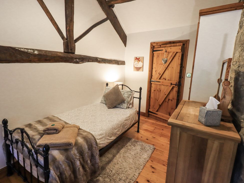 A bedroom with a bed and wooden furniture at The Stables Horton-in-Ribblesdale near Settle