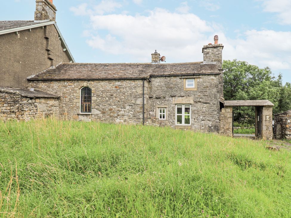 A stone cottage surrounded by grass at The Stables in Horton-in-Ribblesdale near Settle