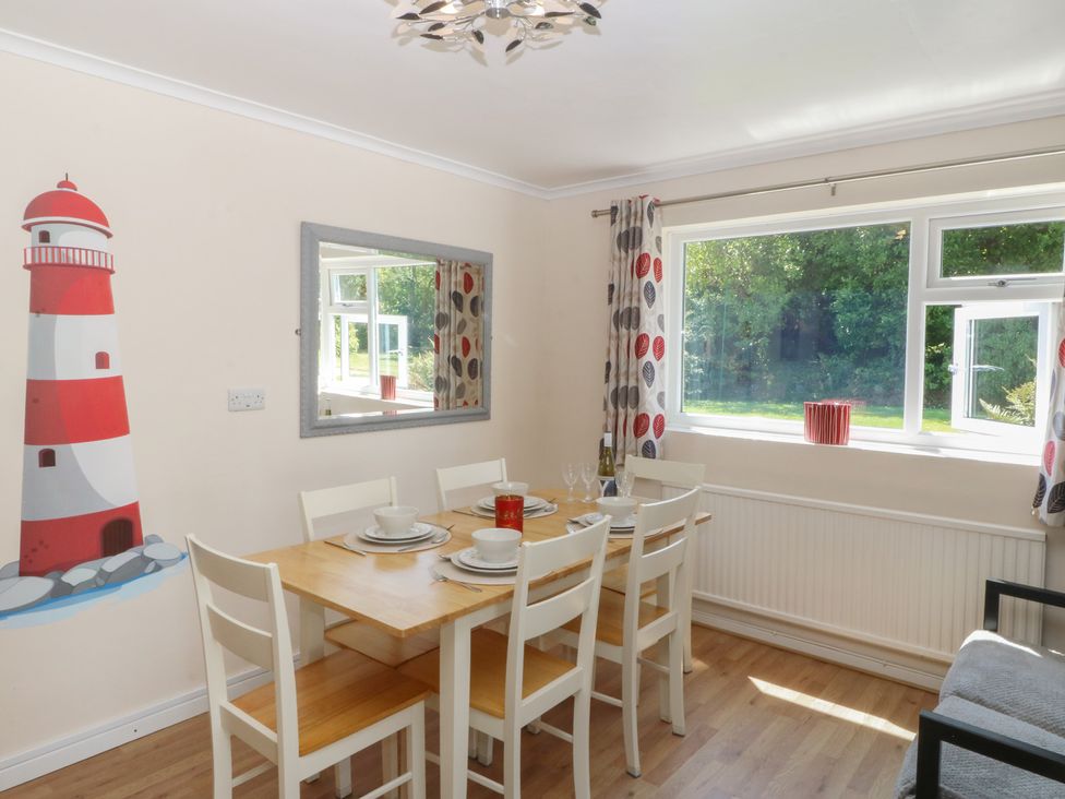 A dining room with a table and chairs at Salty Puffin in Benllech