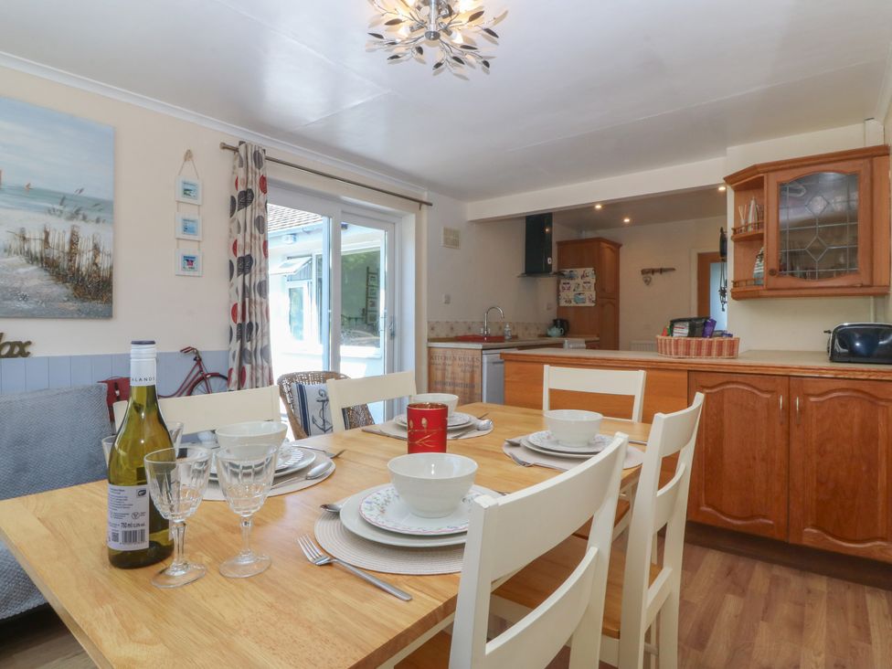 A dining room with a table set for meals at Salty Puffin Benllech